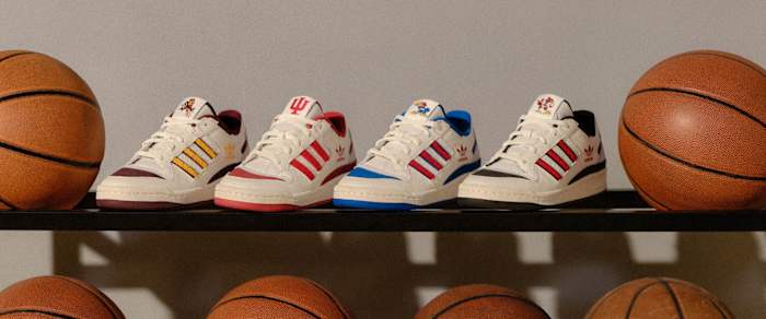 View of adidas basketball sneakers on a ball rack.
